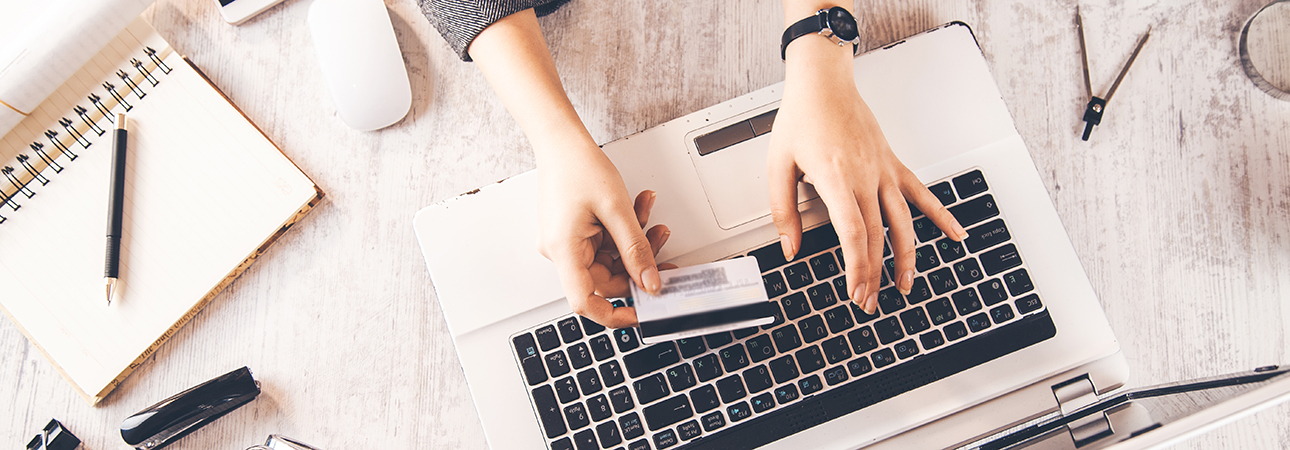 person holding credit card at laptop