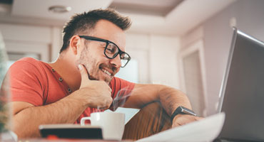 Smiling man using laptop for online shopping