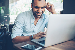 Man sitting at table using laptop