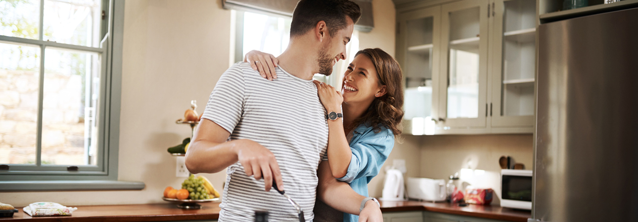 Man and woman happily cooking in kitchen